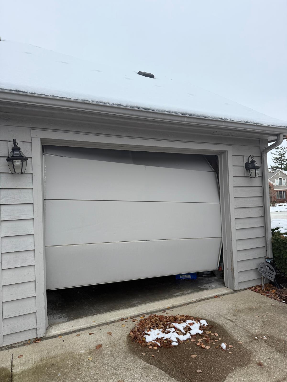Off-track garage door repair in Canton, GA Residential garage door off track and jammed in the opening during a winter service call in Canton, GA