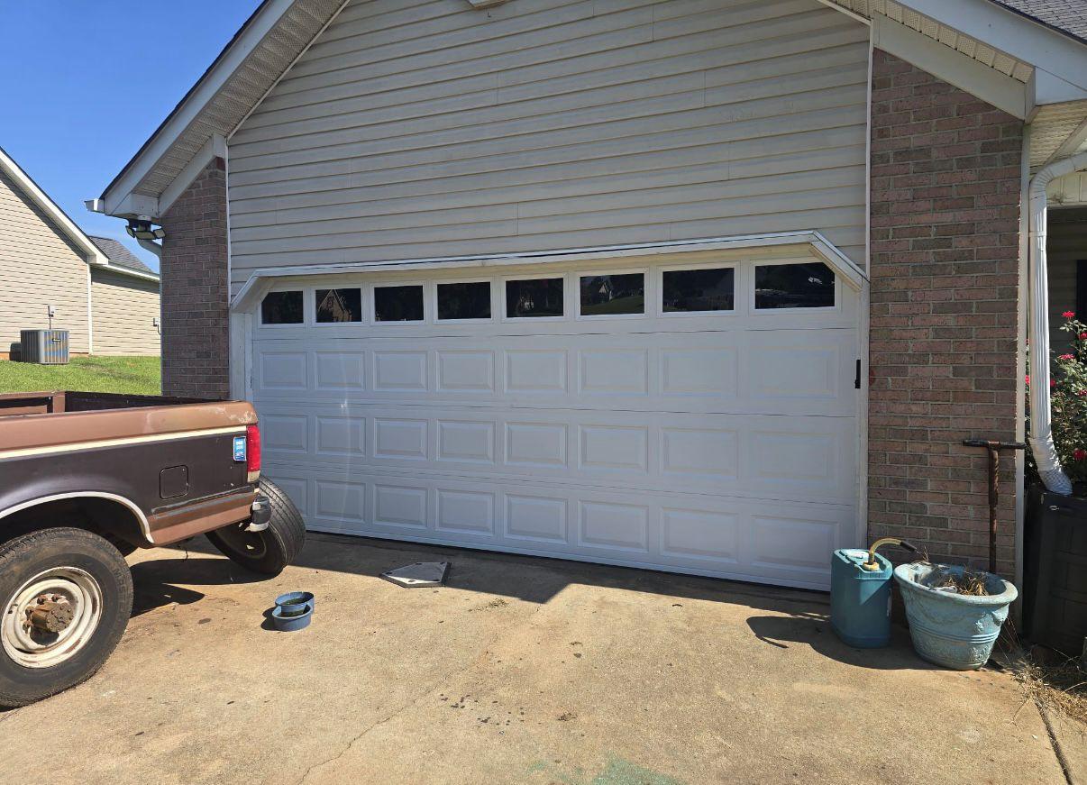 Double garage door installation in Kennesaw, GA New white double garage door with a row of windows installed on a brick and vinyl home in Kennesaw, GA