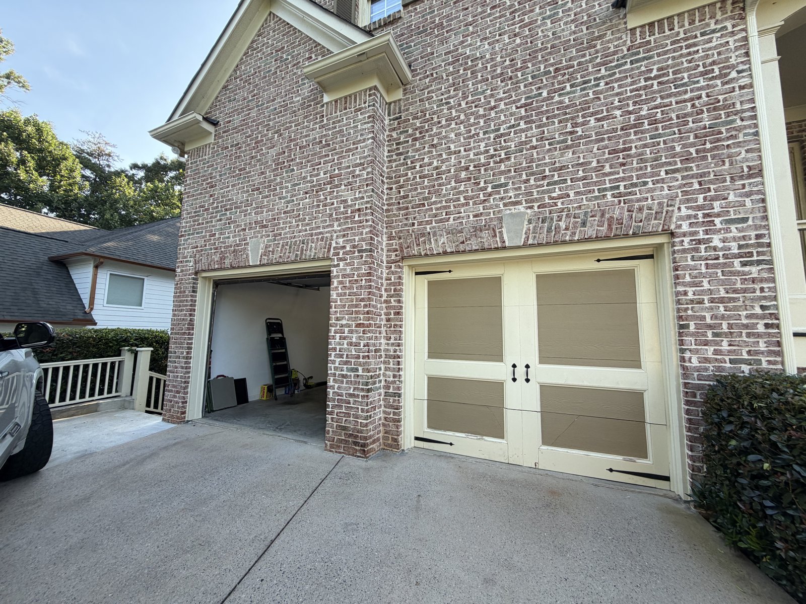 Two-tone carriage garage door Cream and tan two-tone carriage garage door on a painted brick home