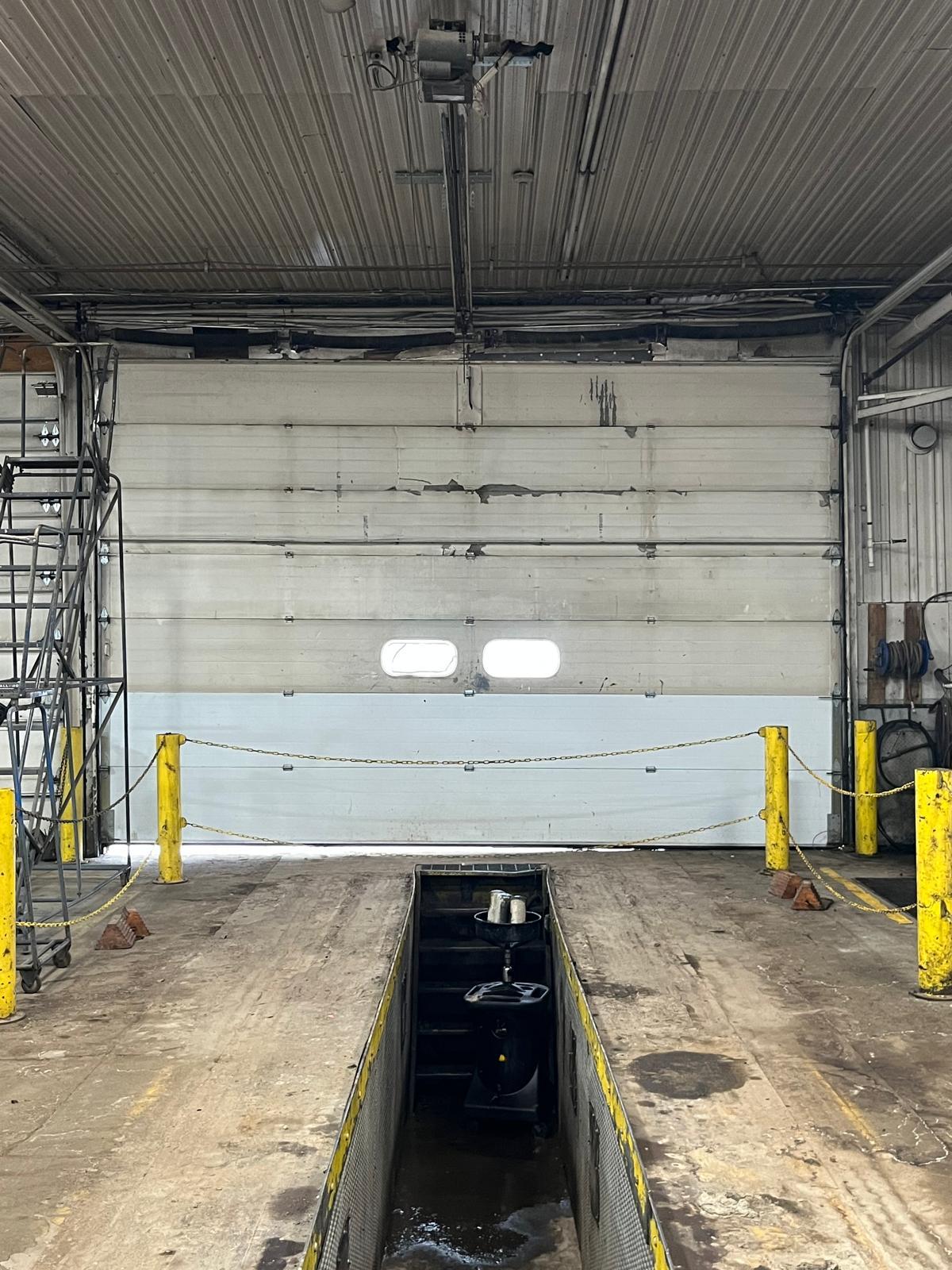 Commercial overhead door service in Ball Ground, GA Commercial overhead garage door in a truck service bay during maintenance in Ball Ground, GA