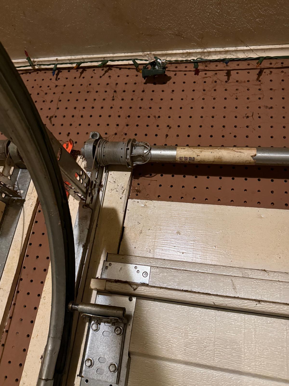 Torsion spring and cable drum replacement in Acworth, GA Torsion spring shaft and cable drum on a 9x7 garage door before spring replacement in Acworth, GA