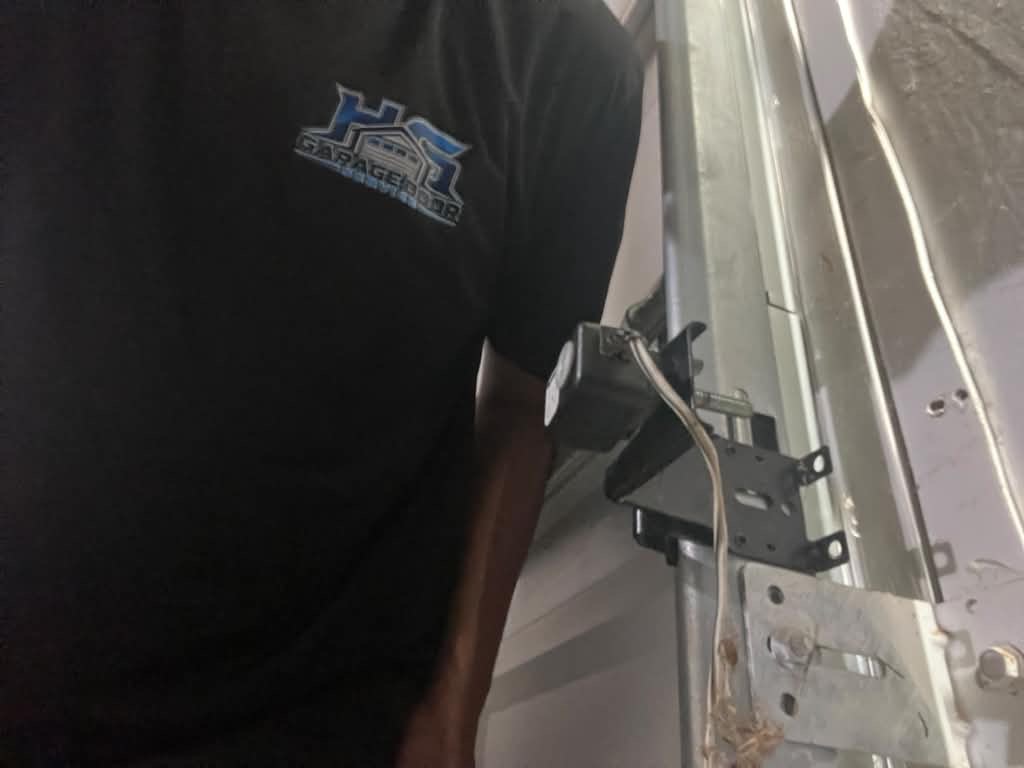 Garage door opener bracket repair in Alpharetta, GA Close-up of a garage door opener bracket and mounting hardware being repaired in Alpharetta, GA