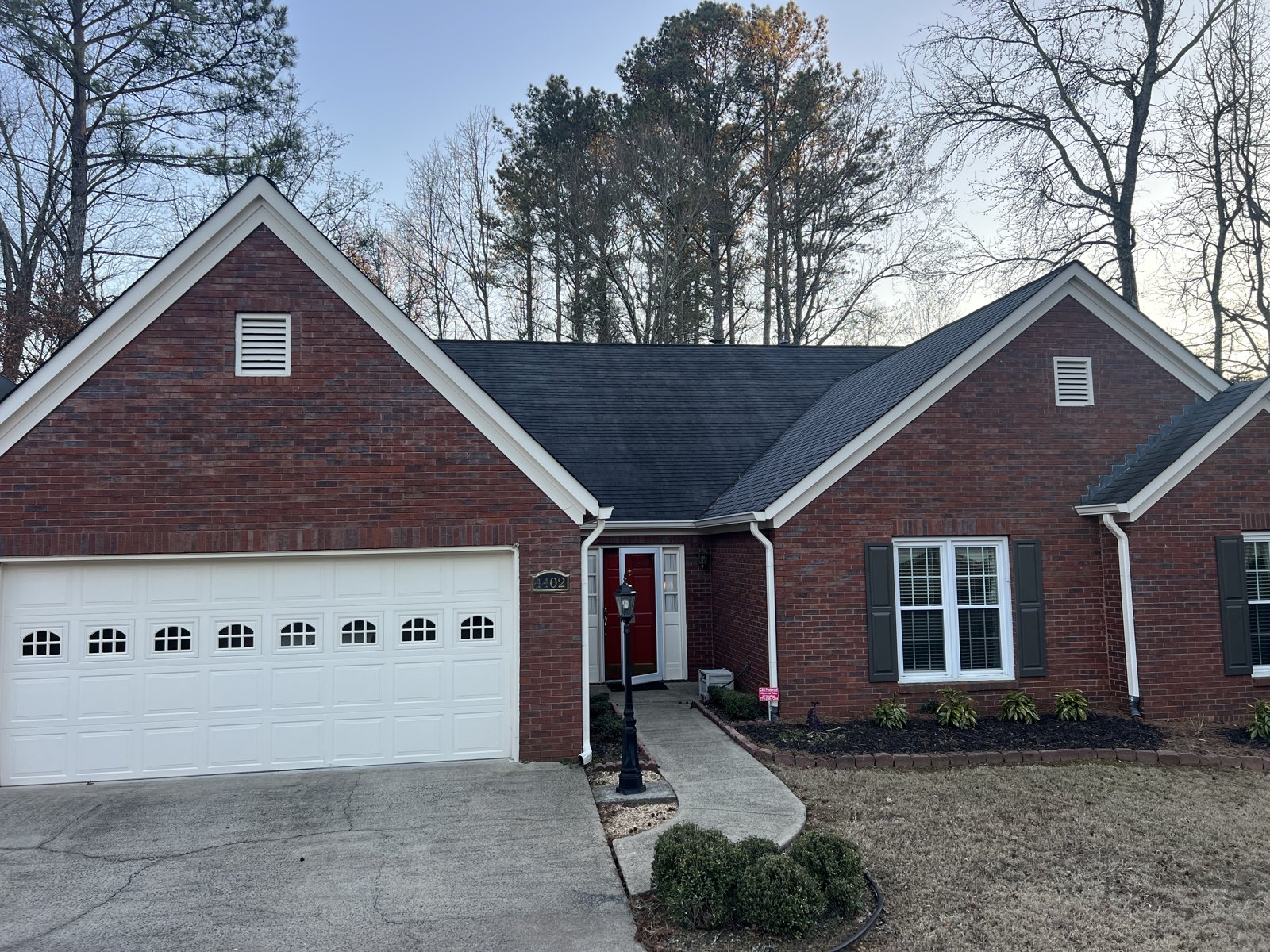 White double garage door with arched windows White double garage door with arched window row on a red brick ranch home