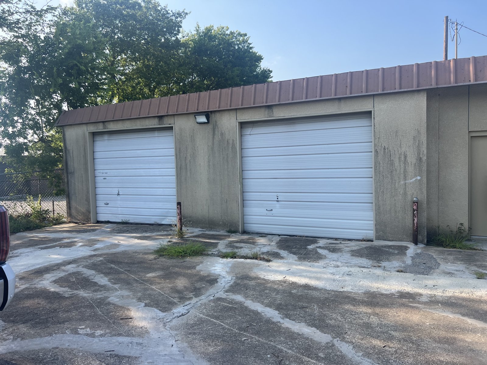 Twin roll-up commercial garage doors Two white roll-up garage doors on a commercial concrete building